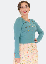 Load image into Gallery viewer, Woman wearing a teal sweater with decorative buttons on a white background