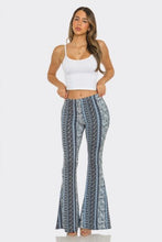 Load image into Gallery viewer, Woman wearing a white tank top and patterned flared pants on a white background