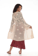 Load image into Gallery viewer, A woman modeling a cream-colored, semi-sheer crochet cardigan with embroidered star and crescent moon patterns, paired with a dark red skirt, against a solid white background.