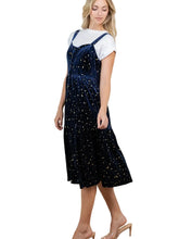 Load image into Gallery viewer, A woman models a navy blue velvet midi dress with gold star patterns, layered over a white short-sleeve t-shirt.