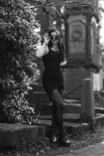 Load image into Gallery viewer, Woman in a black dress standing in a cemetery