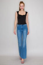 Load image into Gallery viewer, Woman wearing a black tank top and blue jeans against a plain background