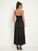 Load image into Gallery viewer, Woman wearing a black tiered dress against a white background
