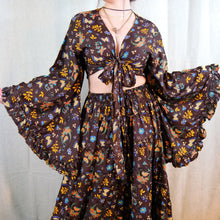 Load image into Gallery viewer, A bohemian-style two-piece dress set featuring a dark brown base with a vibrant multicolor floral and bird print, including yellow, orange, and blue. The set includes a long-sleeve crop top with a front tie and a matching high-waisted flared skirt.