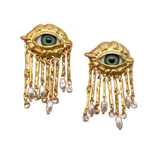 Load image into Gallery viewer, A pair of gold-plated evil eye earrings with pearl embellishments and tassel detail, on a white background.