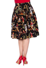 Load image into Gallery viewer, A black high-waisted A-line skirt with a vintage pin-up and western cowboy print, shown on a model wearing red heels against a white background.