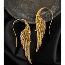 Load image into Gallery viewer, Gold angel wing earrings on a dark fabric background