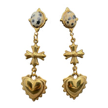 Load image into Gallery viewer, Gold earrings with cross and heart designs on a gray stand.