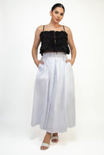 Load image into Gallery viewer, Woman wearing a black top and white pants on a white background