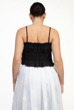 Load image into Gallery viewer, Woman wearing a black top and white skirt on a white background