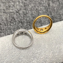 Load image into Gallery viewer, Gold and silver rings on a textured surface with a gray background