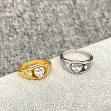 Load image into Gallery viewer, Gold and silver rings with heart-shaped gemstones on a textured surface