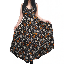Load image into Gallery viewer, Woman wearing a floral dress with a pattern of cats and moons against a white background.
