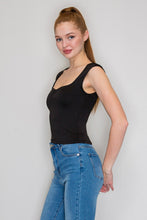 Load image into Gallery viewer, Woman wearing a black tank top and blue jeans against a plain background
