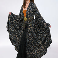 Woman wearing a dark floral patterned kimono-style garment on a white background