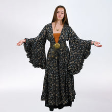Load image into Gallery viewer, Woman wearing a long, patterned dress with wide sleeves on a white background
