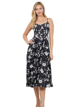 Load image into Gallery viewer, A woman modeling a black midi dress with a white cat print pattern, standing in a bright room.
