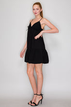 Load image into Gallery viewer, Woman wearing a black dress against a plain background
