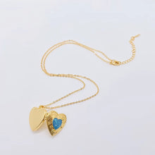 Load image into Gallery viewer, Gold heart-shaped necklace with a blue gemstone on a light gray background
