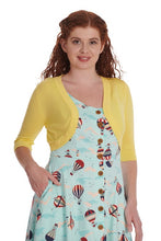 Load image into Gallery viewer, Woman wearing a yellow cardigan over a patterned dress on a white background

