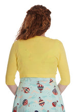 Load image into Gallery viewer, A woman shown from the back wearing a bright yellow ribbed knit cardigan with three-quarter sleeves and a light blue skirt with a red, white, and black hot air balloon pattern, against a plain white background.
