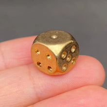 Load image into Gallery viewer, Gold and bronze dice held between fingers against a gray background
