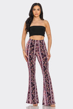 Load image into Gallery viewer, Woman wearing a black strapless top and floral bell-bottom pants on a white background
