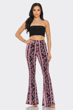 Load image into Gallery viewer, Woman wearing a black top and floral pants on a white background
