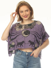 Load image into Gallery viewer, A woman wearing a purple short-sleeve crop top with a celestial cat print, paired with blue jeans, against a plain white background.
