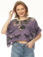 A woman wearing a purple short-sleeve crop top with a celestial cat print, paired with blue jeans, against a plain white background.