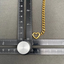 Load image into Gallery viewer, Gold chain with a heart-shaped pendant next to a ruler on a gray background
