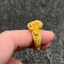 Load image into Gallery viewer, Gold ring with floral design on a finger against a gray background
