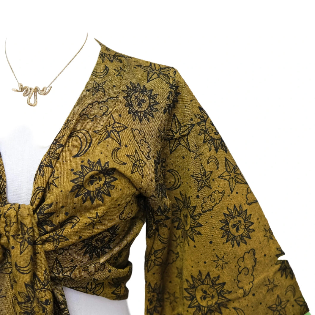 Mannequin wearing a mustard yellow scarf with black celestial pattern against a white background