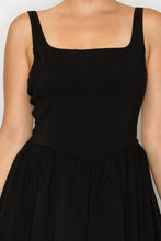 Load image into Gallery viewer, Black sleeveless dress worn by a person on a plain background
