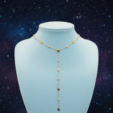 Load image into Gallery viewer, A gold-toned Y-necklace necklace with star and pearl accents, displayed on a light jewelry bust against a starry background.
